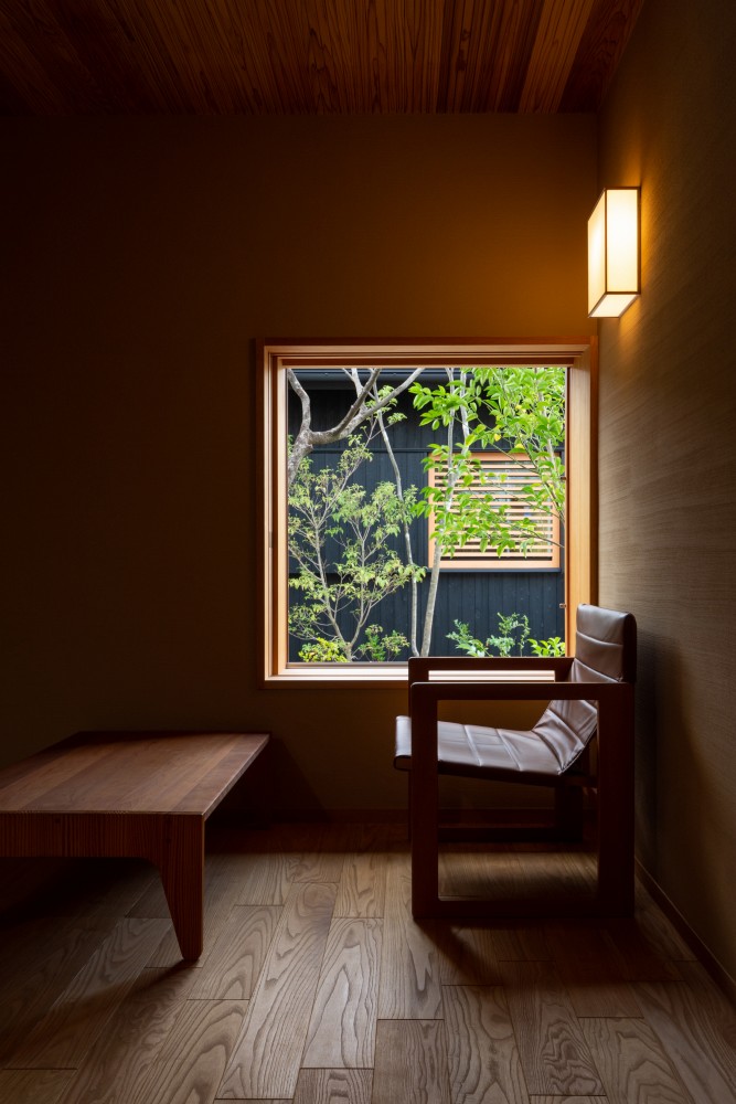 窓高を低く押えた気密性の高い木製サッシ。椅子に座った時にちょうど良い窓高に設定。